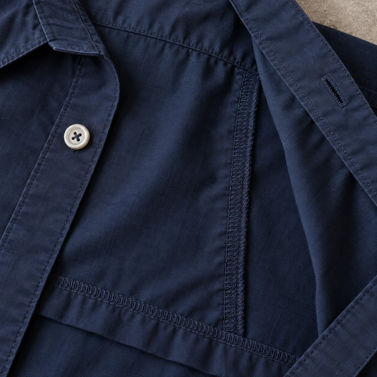 Close view of finished seams and stitching inside a navy shirt